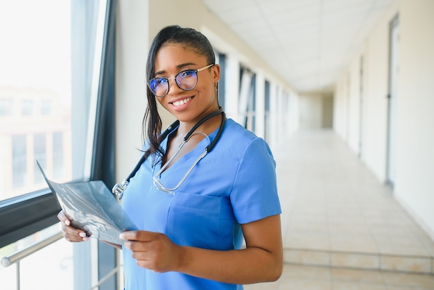 Joven médico afroamericano profesional examinando la radiografía del tórax de los pacientes