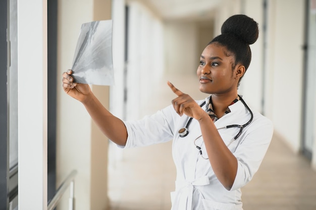 Joven médico afroamericano profesional que examina la radiografía del tórax de los pacientes