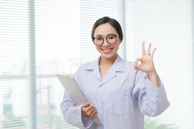 Joven médico alegre feliz en uniforme blanco gesticulando bien. Concepto de salud bucal