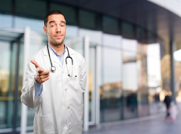 Joven médico apuntando con su mano