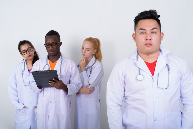 Joven médico asiático con diverso grupo de colegas multiétnicos