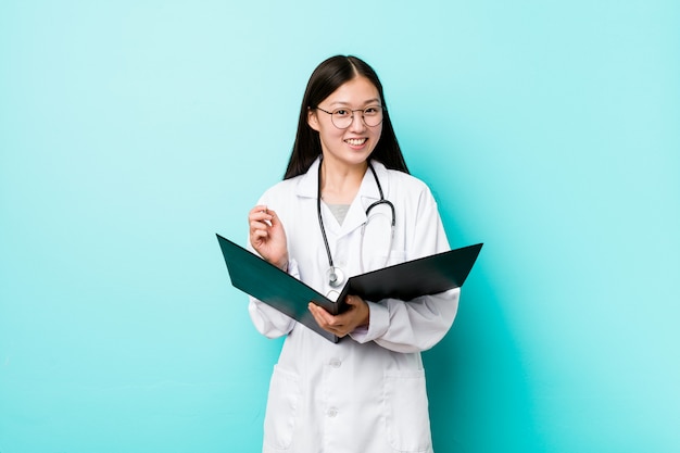 Joven médico asiático mujer sosteniendo una carpeta