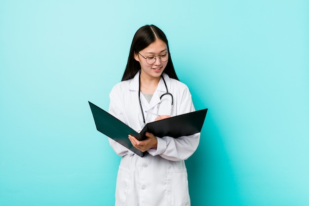 Joven médico asiático mujer sosteniendo una carpeta