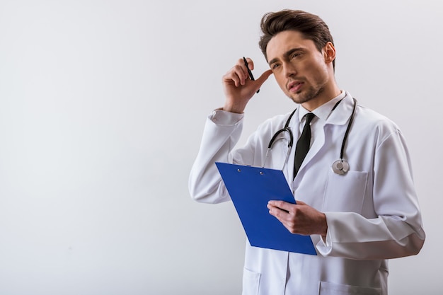 Joven médico en bata blanca y con estetoscopio.