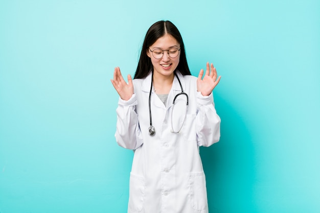 Joven médico chino mujer alegre riendo mucho. Concepto de felicidad