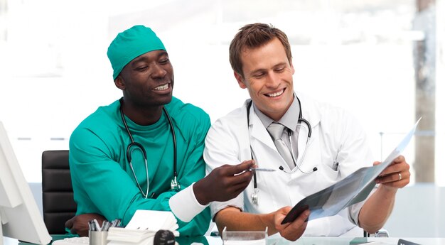 Joven médico y cirujano mirando una radiografía