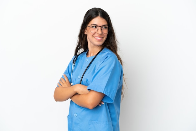 Joven médico cirujano mujer caucásica aislada sobre fondo blanco con los brazos cruzados y feliz