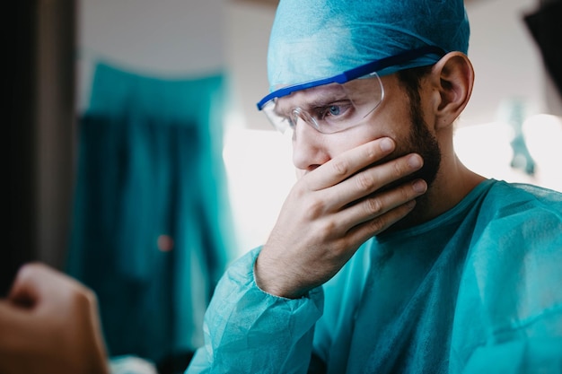 un joven médico cirujano uniformado trabaja en un hospital en la pantalla