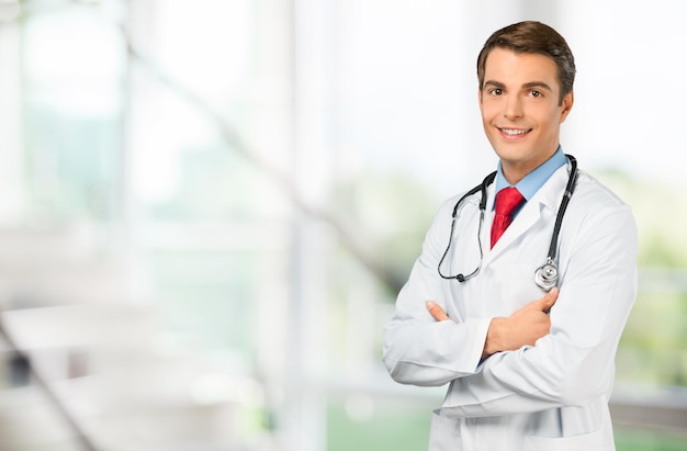 Joven médico con estetoscopio en la clínica