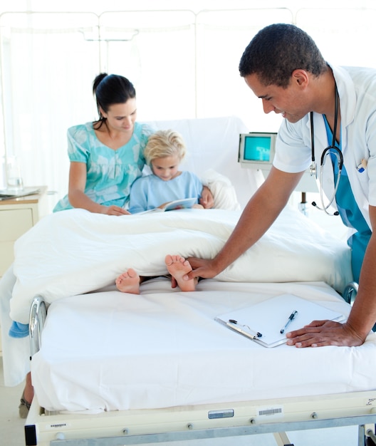 Joven médico examinando a un niño paciente