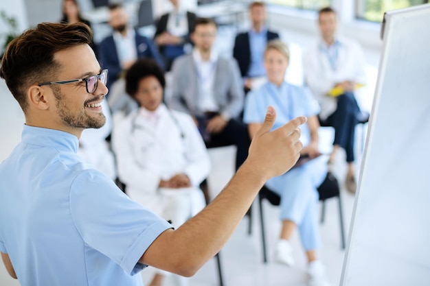 Foto joven médico feliz celebrando un seminario de atención médica en el centro de convenciones