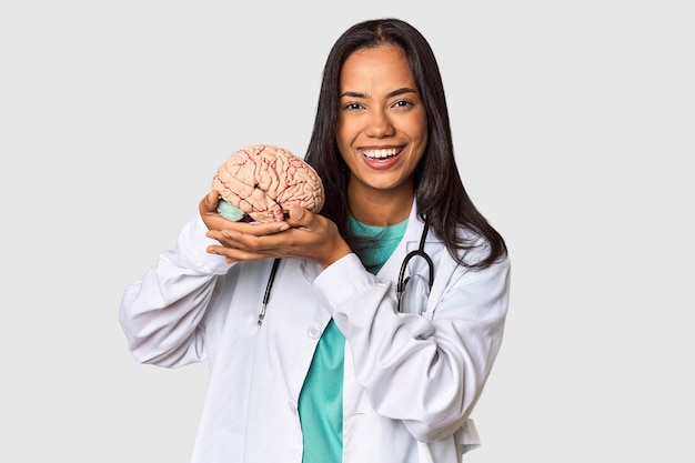 Foto joven médico filipino con un modelo de cerebro en el estudio