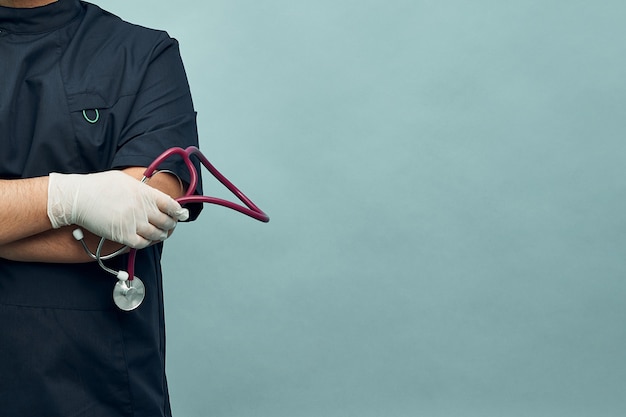 Un joven médico con guantes protectores y un estetoscopio