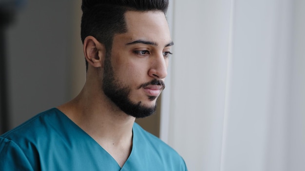 Joven médico hispano pensativo varón pensativo árabe enfermero practicante terapeuta cirujano stand