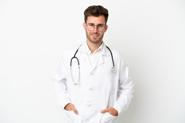 Joven médico hombre caucásico sobre aislado sobre fondo blanco vistiendo una bata de médico y con estetoscopio