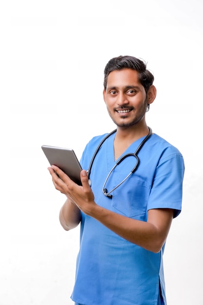 Joven médico indio con smartphone sobre fondo blanco.