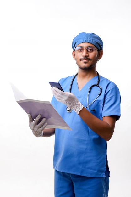 Joven médico indio con smartphone sobre fondo blanco.