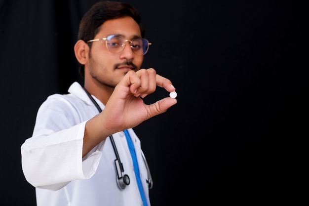 Joven médico indio sosteniendo la píldora en la mano.