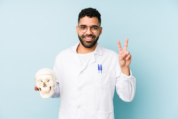 Joven médico latino sosteniendo una calavera