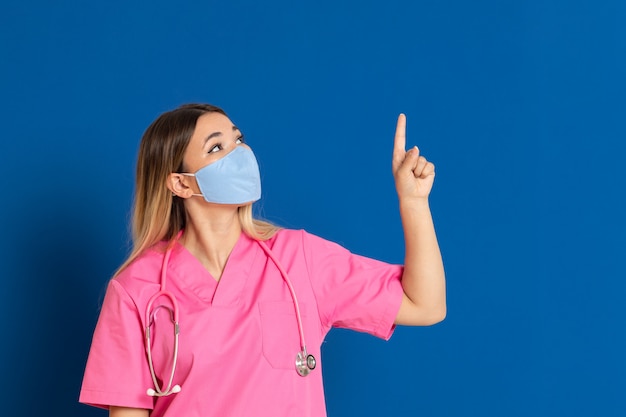 Joven médico con una máscara y un uniforme rosa