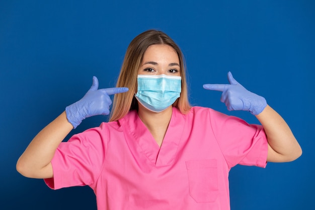 Joven médico con una máscara y un uniforme rosa