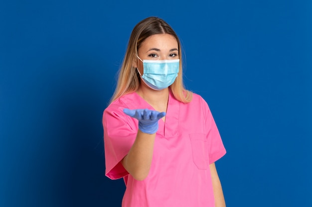 Joven médico con una máscara y un uniforme rosa