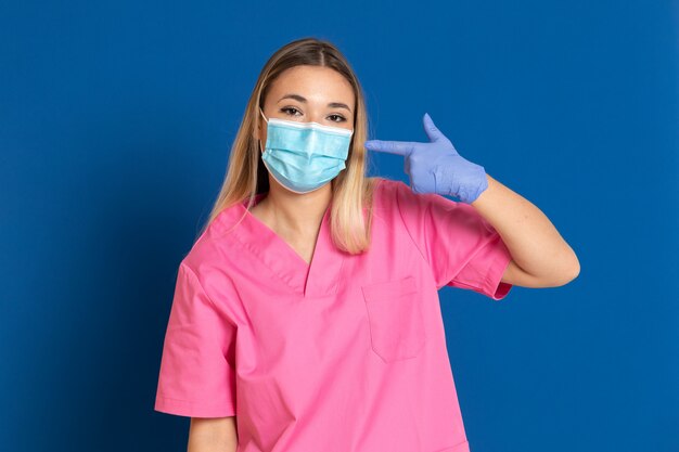 Joven médico con una máscara y un uniforme rosa