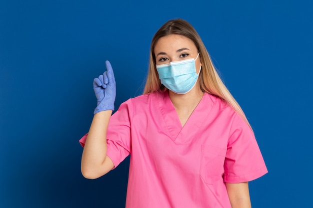 Joven médico con una máscara y un uniforme rosa