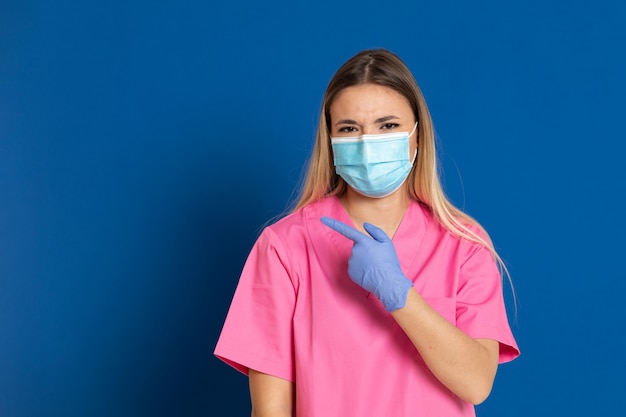 Joven médico con una máscara y un uniforme rosa