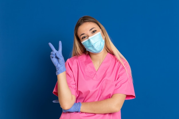 Foto joven médico con una máscara y un uniforme rosa