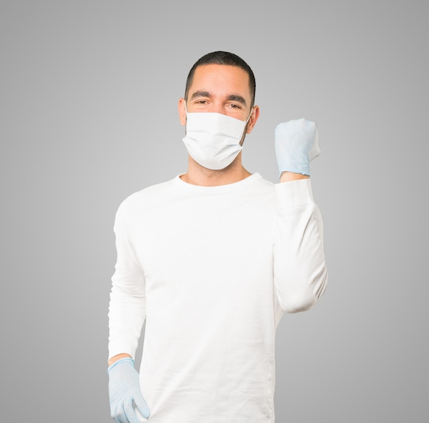 Joven médico masculino con máscara y guantes protectores