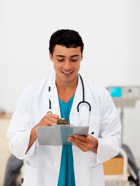 Joven médico masculino sosteniendo un tablero de clip