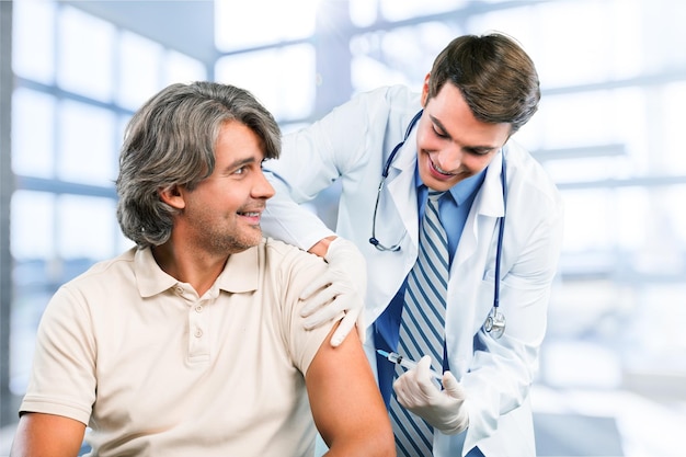 Joven médico masculino vacunando al paciente