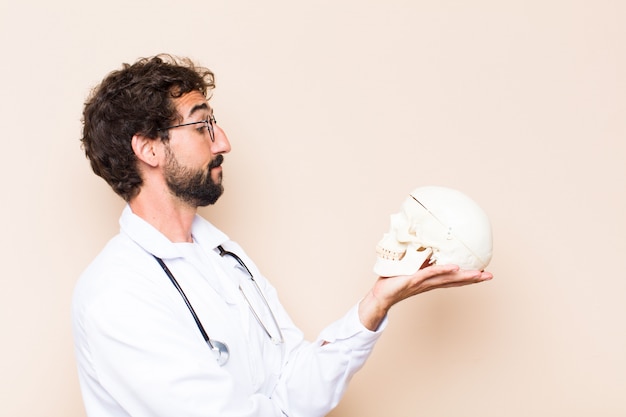 Joven médico y un modelo de cráneo humano