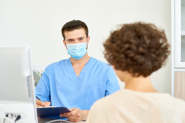 Joven médico con paciente