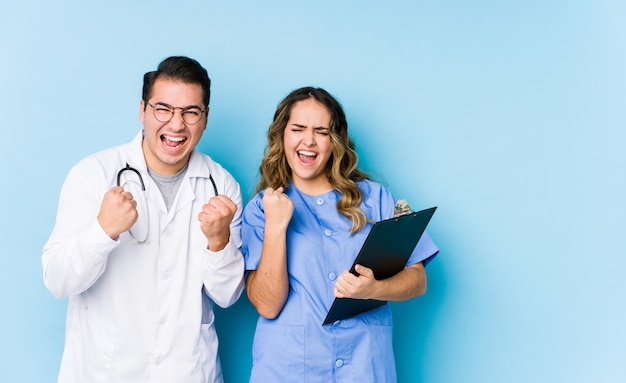 Joven médico pareja posando y animando despreocupado y emocionado