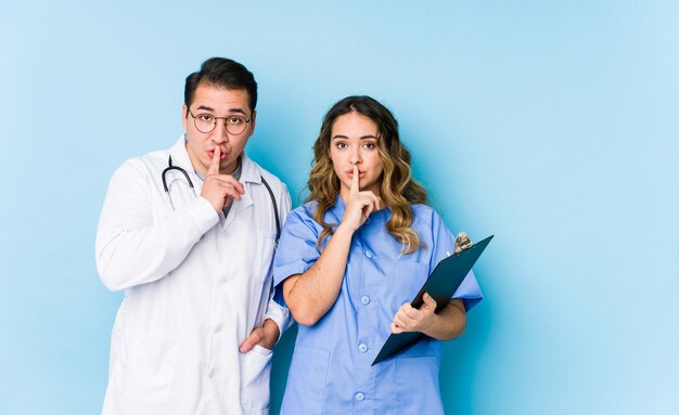 Joven médico pareja posando en azul
