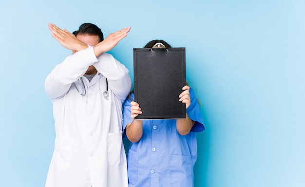 Joven médico pareja posando en azul