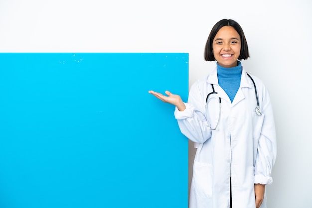 Joven médico de raza mixta mujer con un gran cartel aislado sobre fondo blanco sosteniendo copyspace imaginario en la palma para insertar un anuncio
