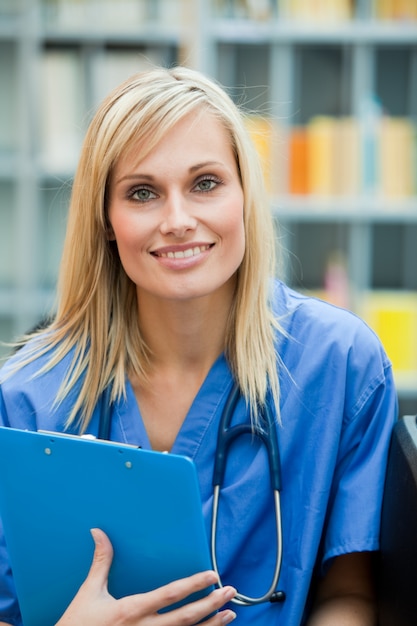 Joven médico rubio en el trabajo sonriendo a la cámara