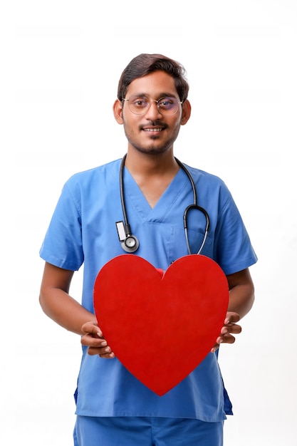 Joven médico sosteniendo una hermosa forma de corazón rojo en la mano