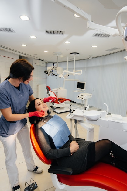 Foto un joven médico trata los dientes de su paciente. odontología