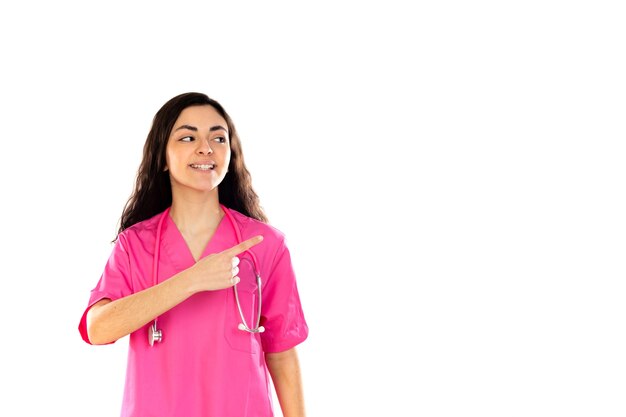 Joven médico con uniforme rosa aislado en una pared blanca