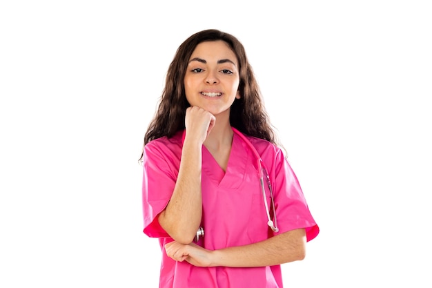 Joven médico con uniforme rosa aislado en una pared blanca