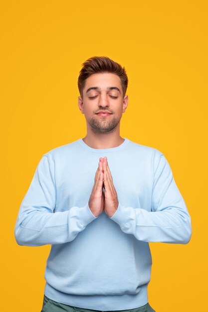 Joven meditando con las manos juntas