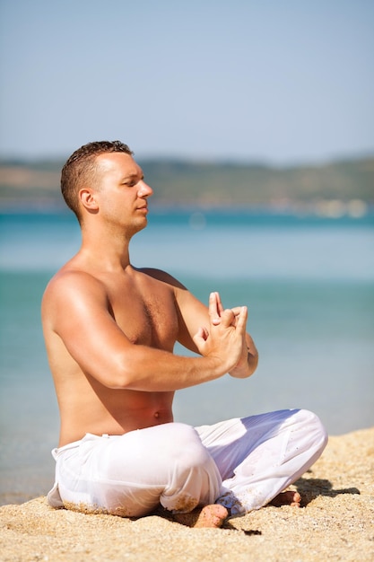 Joven meditando en la playa