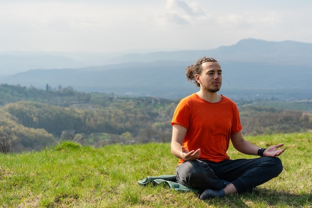 Joven meditando yoga en el pico de la roca Relajarse y calmarse