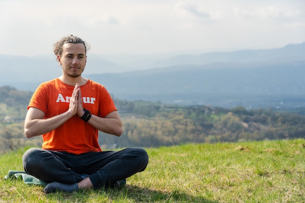 Joven meditando yoga en el pico de la roca Relajarse y calmarse