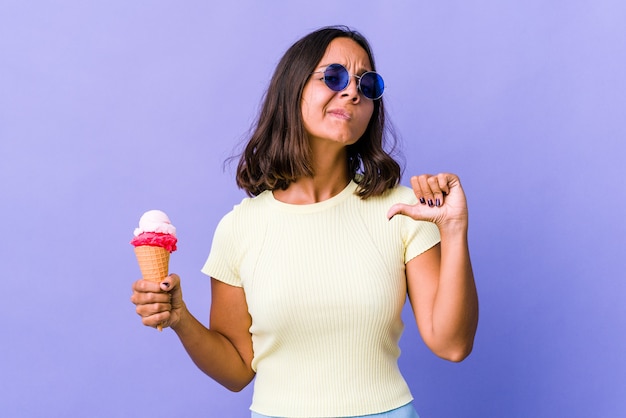 Joven mestiza comiendo un helado se siente orgullosa y segura de sí misma, ejemplo a seguir.