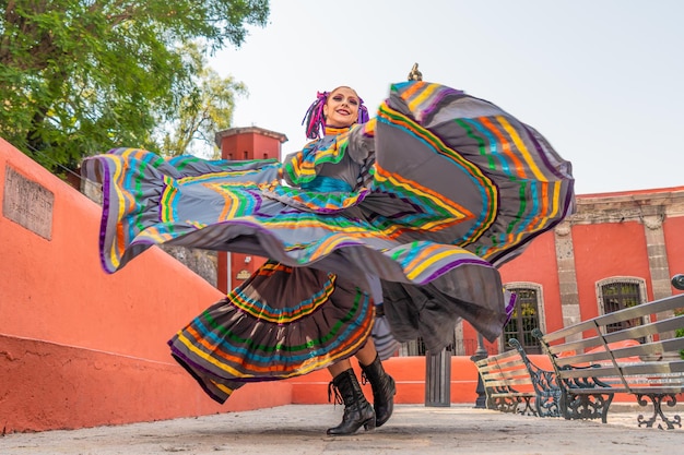 Joven mexicana con un vestido folclórico tradicional de bailarina tradicional de muchos colores